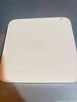 Top view of white square Apple AirPort Extreme showing Apple logo