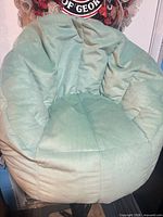 Front view of turquoise bean bag chair on pedestal base