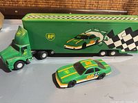 Transport truck with trailer and racing car shown together