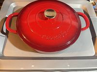 Top view showing red Dutch oven with lid and embossed logo