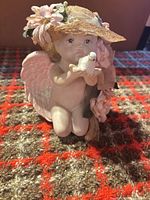 Front view of cherub figurine holding dove