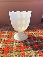 Full view of vase showing thumbprint pattern and pedestal foot