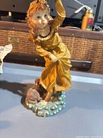 Front view of Giuseppe Armani figurine showing girl in yellow dress holding flowers, dog at base