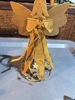 Front view of gold wire angel tree topper showing wings, skirt, stars