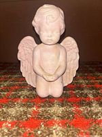Front view of pink ceramic kneeling cherub figurine