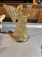 Front view of silver-plated angel candle holder showing cup and wing detail