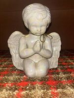 Front view showing kneeling cherub, clasped hands, iridescent glaze