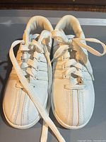 Top view of both sneakers showing five-stripe design and laces