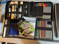 Open KALOUR art set showing pencils, accessories and sketchbook