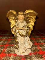 Front view of angel figurine showing robe, dove, and gold wings