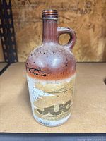 Front view of Mogen David Strawberry Glen glass jug showing label and paint wear