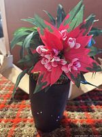 Front view artificial poinsettia in black pot
