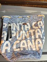 Front view of blue and white tote showing large text and zipper pocket