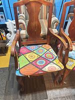 Front view showing splat back, arms, cabriole legs, patterned seat