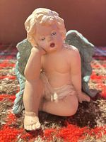Front view of seated cherub showing overall form and color