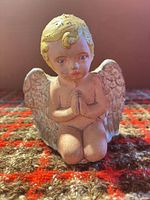 Front view of kneeling cherub figurine