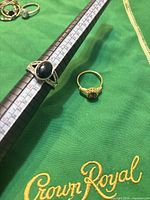Yellow-tone halo ring and silver-tone cabochon ring on mandrel showing size 9