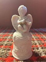 Front view of bisque porcelain bell with cherub playing violin
