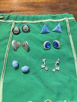 All six pairs of earrings laid out on green cloth