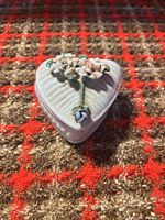 Closed heart-shaped trinket box showing ribbed lid and applied flowers