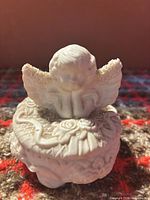 Front view of trinket box showing cherub and floral relief