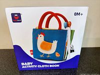Front of boxed Hahaland baby activity cloth book showing chicken graphic and 0M+ age label