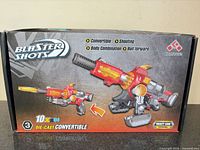 Front of box showing toy gun image, brand, model and features