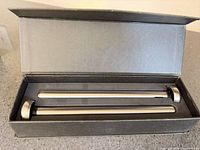 Open box showing two stainless steel chiller sticks with black seals