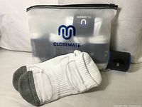 Package with Closemate logo, two loose socks, size band