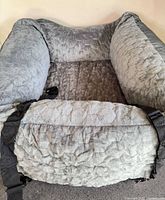 Grey quilted dog car seat bed showing interior padding, straps visible