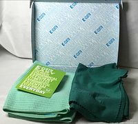 Open box showing two green cloths and insert