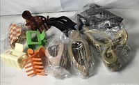 Group shot of all ten claw clips in assorted colours and shapes, some bagged