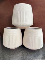 Three matching ceramic planters stacked to show exterior texture and color