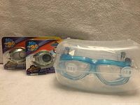 Group shot of all three goggles showing two packaged 3D goggles and cased blue goggles