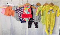 Seven baby garments hanging on rack