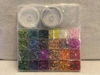 Front of sealed organiser showing 24 compartments of coloured bugle beads and two cord rolls