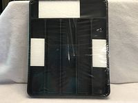 Front view of sealed black plastic cutlery organizer showing compartment layout
