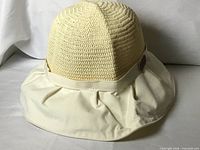 Front view of cream sun hat showing crocheted crown and fabric brim