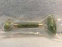 Sealed jade facial roller in plastic showing both jade rollers and handle