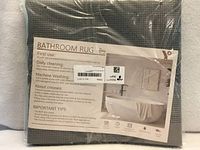 Front of sealed package showing product information sheet and rug texture