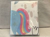Front of sealed package showing folded fabric with unicorn mane colours visible