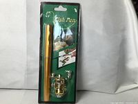 Front of package showing gold pen-style rod and micro reel