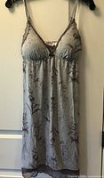 Front view of grey floral nightie hanging to show design, lace trim, straps