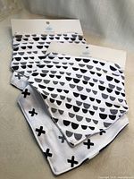 Front view of both sealed packages showing four bandana bibs with prints