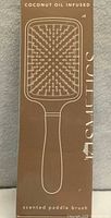 Front of box showing coconut oil infused scented paddle brush packaging