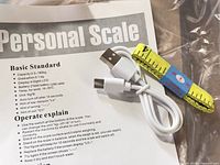 Manual showing scale specifications and included USB cable and tape measure