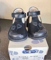 Front view of navy toddler shoes on original box