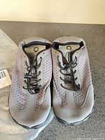 Top view of pair of dark grey hiking water shoes showing mesh uppers and elastic laces