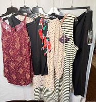 Group shot of six clothing items on hangers showing colours, styles and attached tags