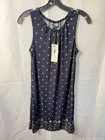 Front view of navy sleeveless dress with tag